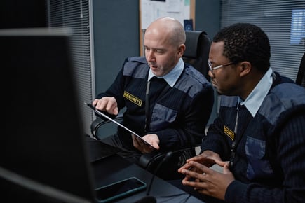 Two security officers looking at SecurityRecords on the tablet are Instant Audit Ready