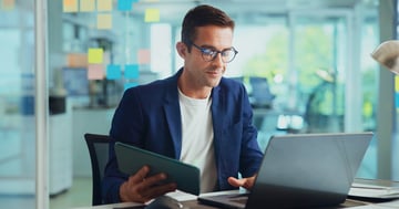 man at desk assigning credentials to users on laptop