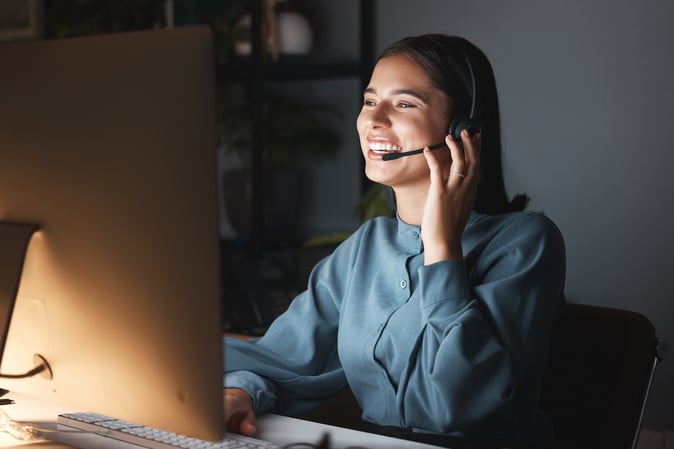 Happy Managed Service staff on phone headset at computer 